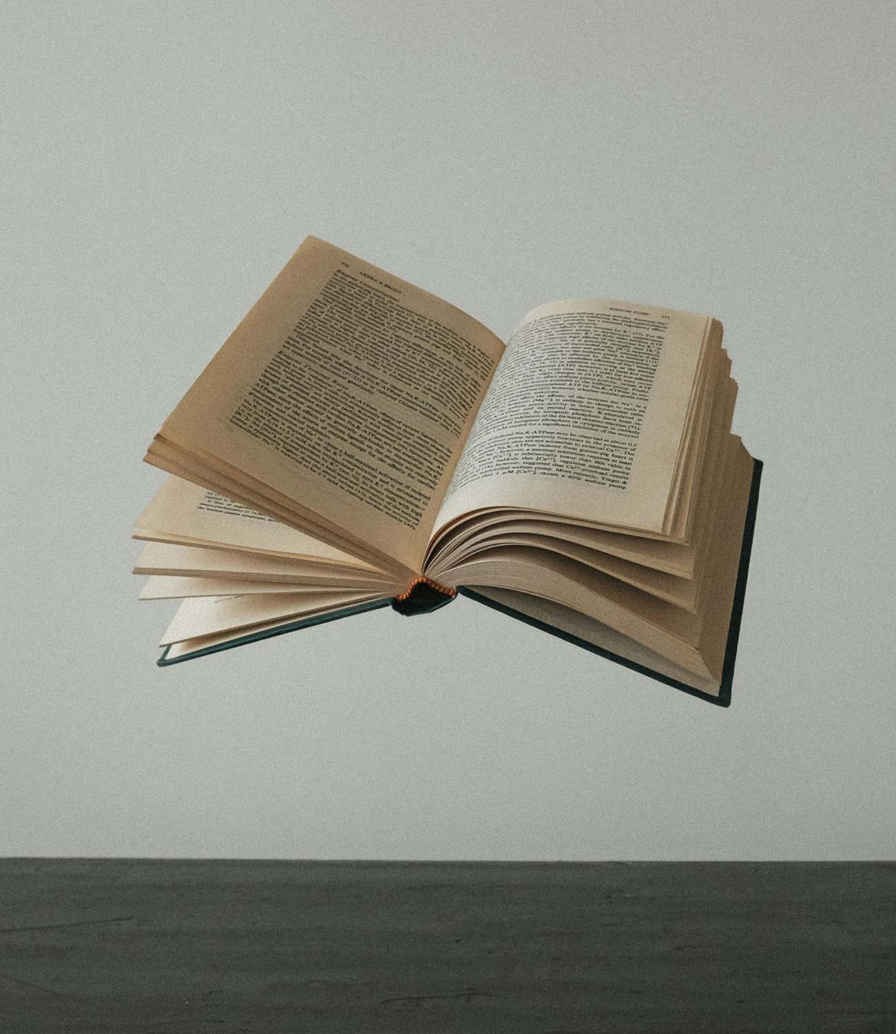 Un libro abierto flotando sobre una superficie gris (portada movil).